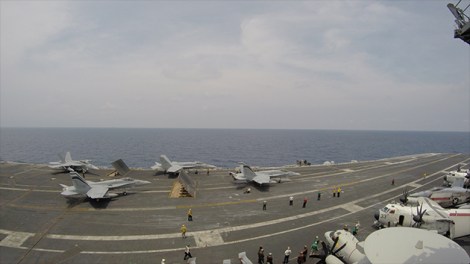 A cluster of fighter jets waiting to take-off on the USS Carl Vinson.